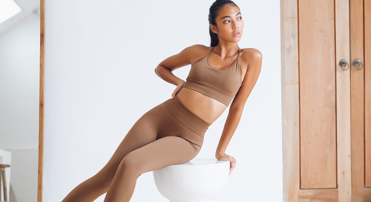 Model in activewear poses elegantly indoors.