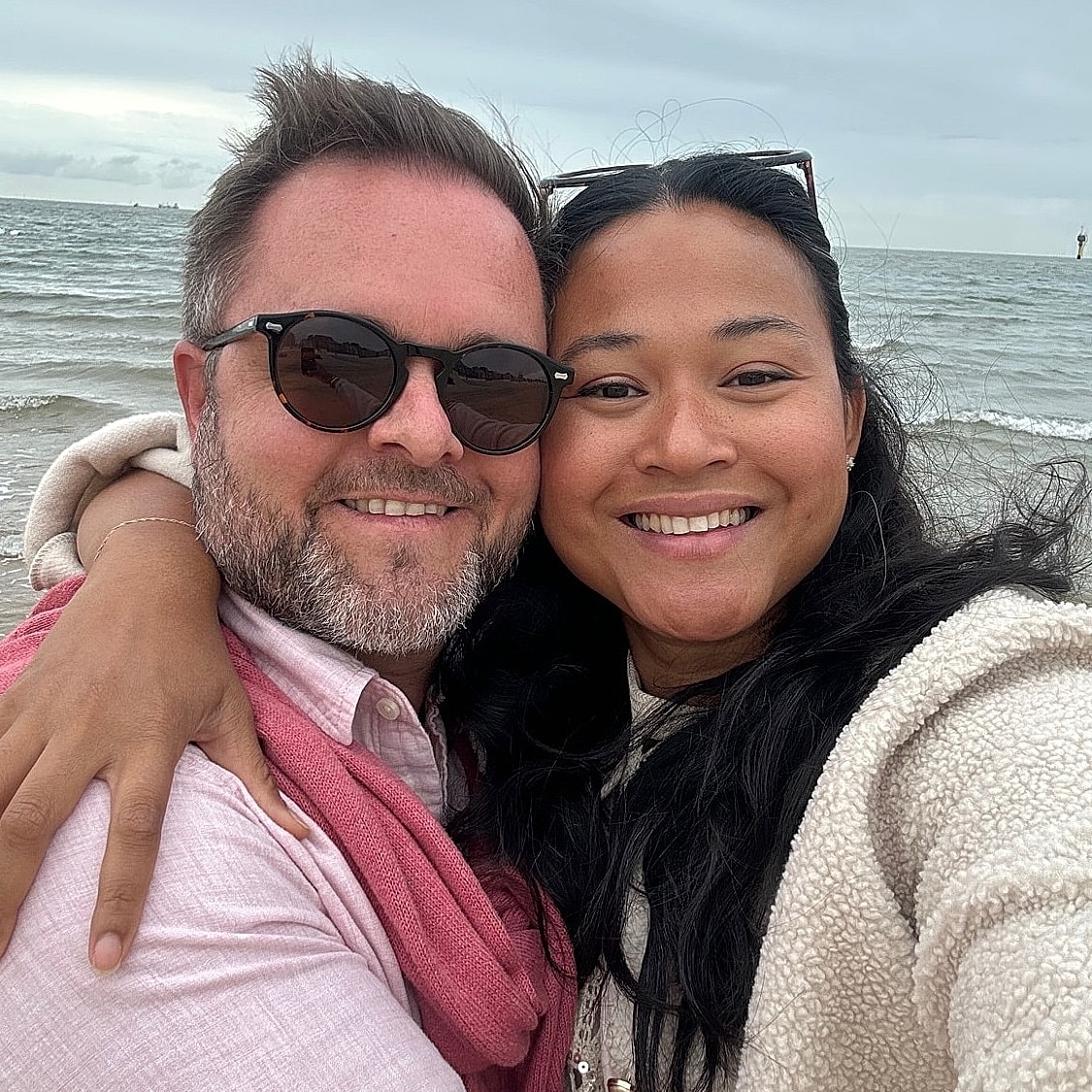 Couple enjoying a beach day together, smiling.