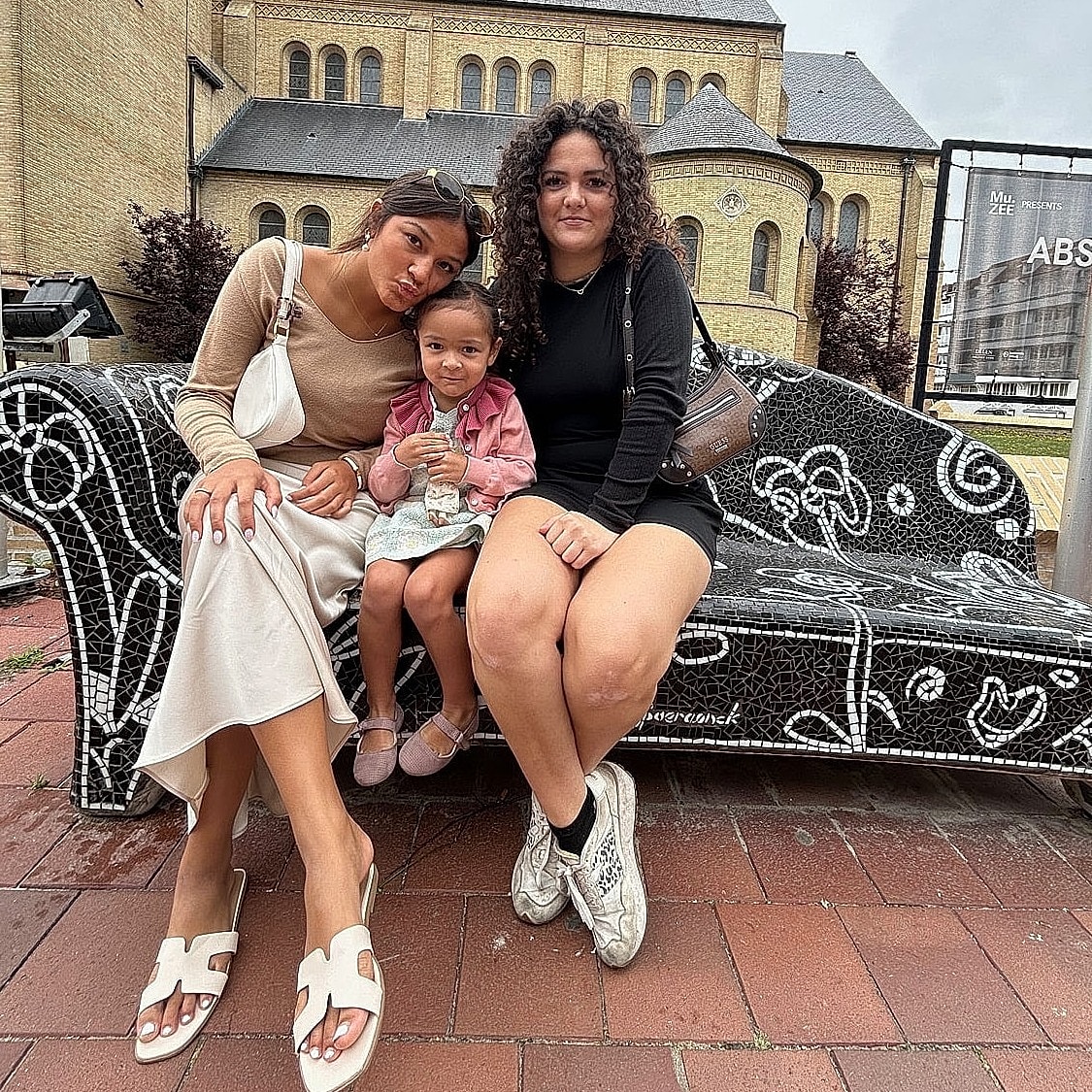 Three women and a child sitting together outdoors.