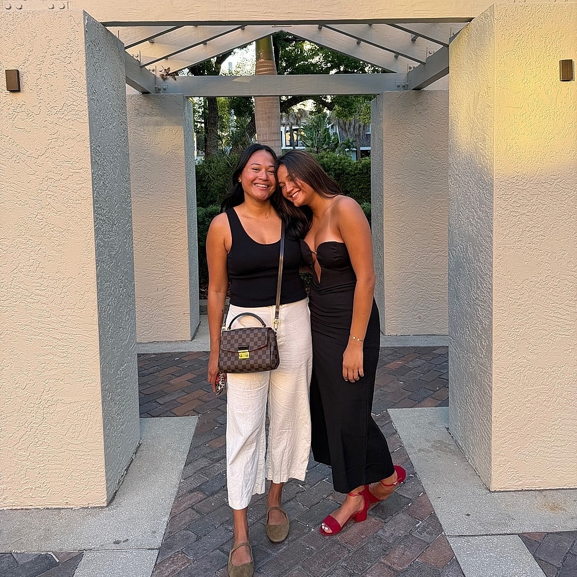 Friends posing together under a pergola.