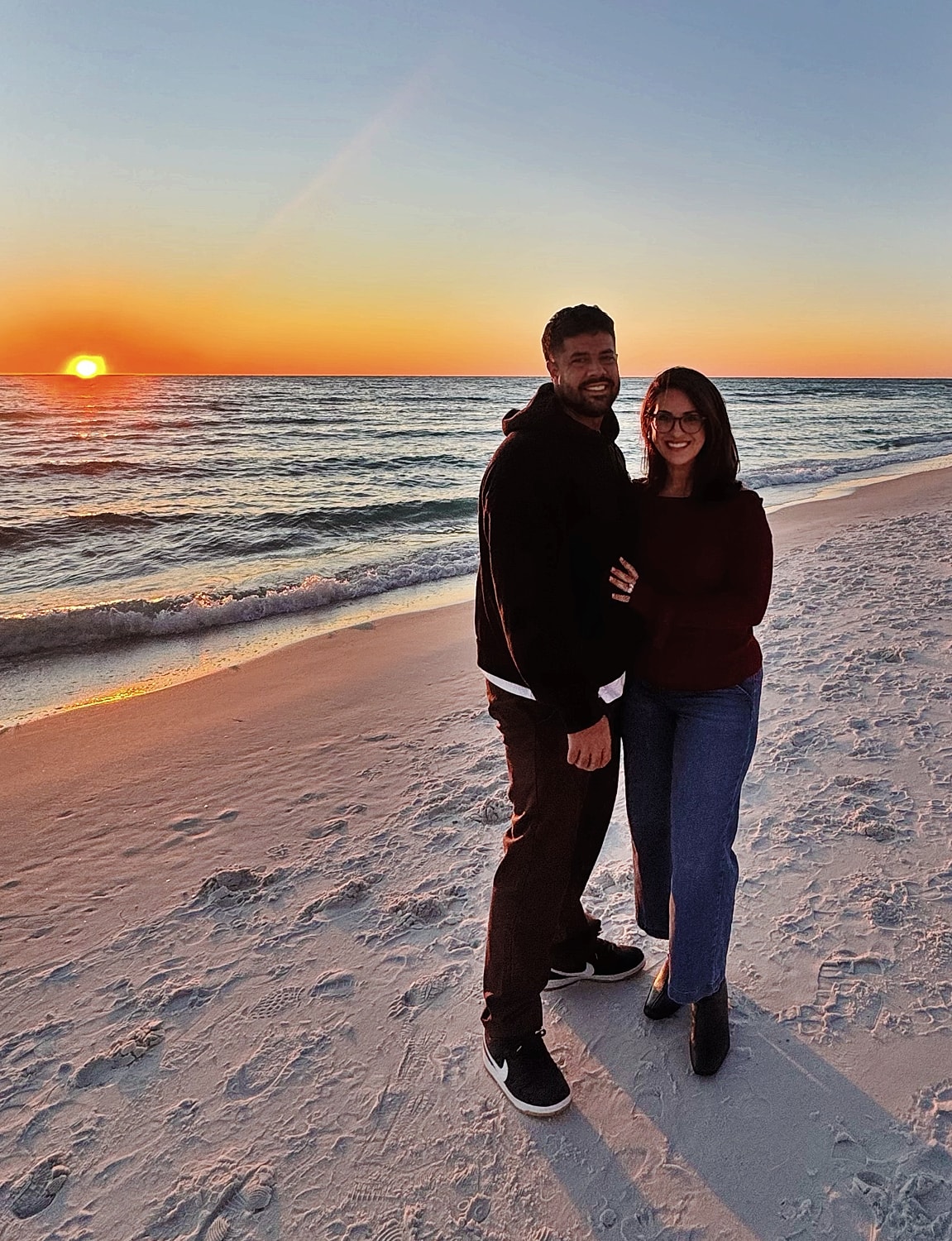 Couple enjoying sunset on beach together.