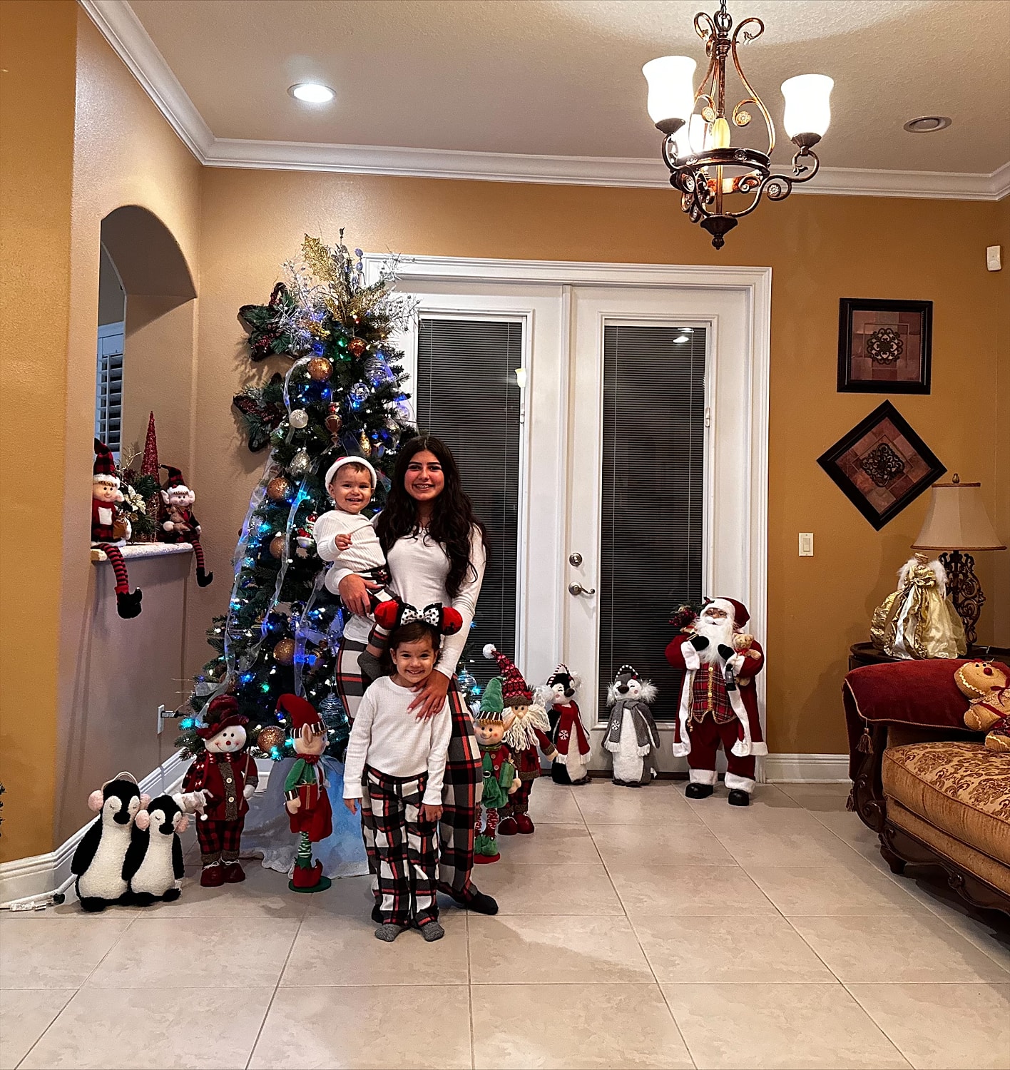 Family celebrating Christmas by the decorated tree.